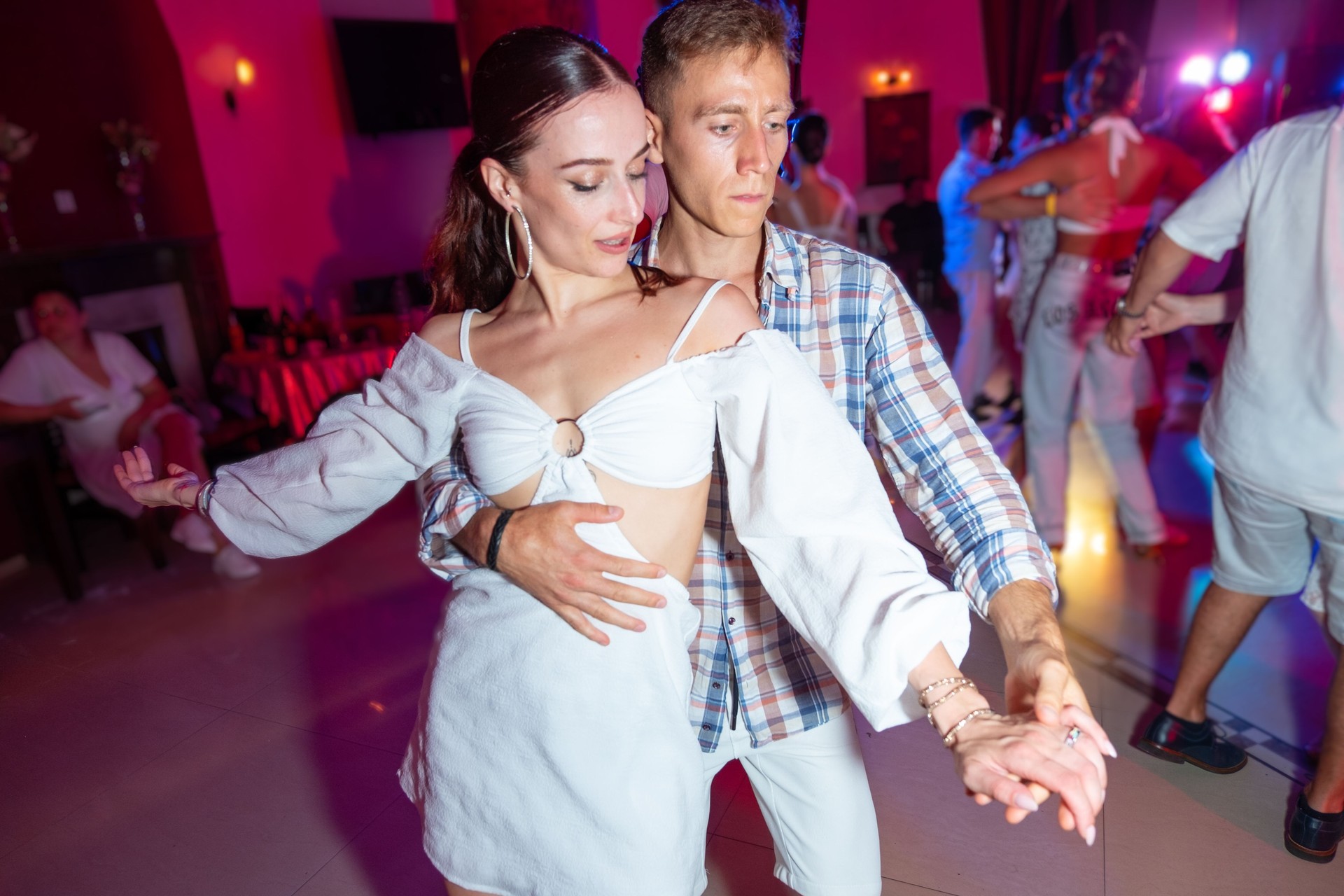 Couple dancing sensual bachata at party.